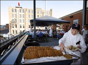 Sister Jeanne Ward adds a cookie to her plate during the cookout at Fifth Third Field.