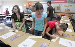 C From left: Sixth-graders Rose Younglove, Sarah Kaiser, and Abigail Fleszar choose their classroom seats during an open house of the Hollywood campus.