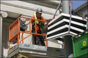 Steven Baker, an aide to Cork Marcheschi, helps to guide a section of the column into place. It took a five-man crew 11 hours to assemble the structure yesterday.