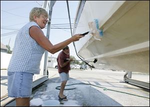 ROV boat04p  09/03/09  The Blade/Dave Zapotosky Diane and Chuck Miller of Toledo clean their boat at River View Yacht Club on Edgewater Drive in Toledo, Ohio, Friday, September 4, 2009.  The couple will be taking the boat to Kelleys Island on Saturday.  Chuck, who has been a boater for about 50 years, said he minimizes the need to paint the bottom of the boat by cleaning it regularly.