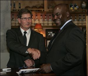 Toledo mayoral candidates Keith Wilkowski, left, and Mike Bell greet each other at the forum at The Docks.