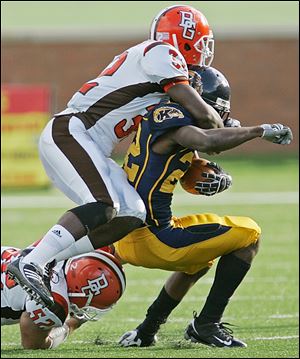 Jerell Parks, top, and James Schneider of Bowling Green stop Kent State's Jacquise Terry Saturday in Kent, Ohio. The Falcons have not lost in Dix Stadium since 1999.

