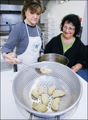 Rhonda Meifert, left, and Andrea Bassett make arroon nut-filled cookies for St. George Antiochian Orthodox Cathedral's annual dinner.