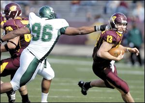 Central Michigan's Dan LeFevour (1,549 passing yards this year) eludes Eastern Michigan Brandon Slater. 