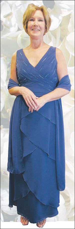 Diane Dooley models a mother's dress with popular tiered skirt in cobalt chiffon accented with beading at Atlas Bridal Shop.