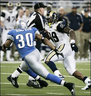 The Rams' Steven Jackson avoids umpire Bill Schuster while being pursued by Lions safety Ko
Simpson on a 25-yard touchdown run in the fourth quarter that sealed the win for St. Louis.