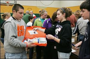 CTY kits23p  11/22/2009    Blade Photo/Lori King  Eddie Mader, 14, goes through the line to help make 200 volunteer caregiver kits at St. Joseph Catholic Parish Community Center Gymnasium in Maumee, OH. Putting an item in his hard kit is Jessica Buehler, 14.