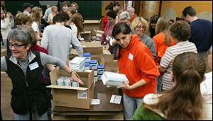 CTY kits23p  11/22/2009    Blade Photo/Lori King  Emmy Bates, left, and Lisa Seibert help fill 200 volunteer caregiver kits at St. Joseph Catholic Parish Community Center Gymnasium in Maumee, OH.