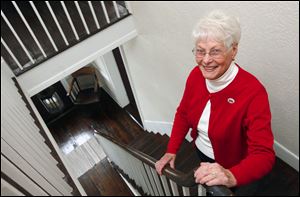 A staircase in the McPherson residence provides the backdrop for Pat Gill, president of the Clyde Heritage League. The group recently completed a $50,000 renovation of the home.