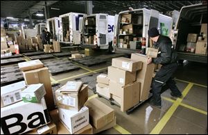 Jim McConkey loads boxes into his truck at the FedEx hub in Perrysburg Township. The hub expects Thursday to be its busiest day.