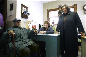 Clara Petty, standing, executive director of The Bridge, talks with George Saunders, Sr., and the Rev. Karen Shepler. The Bridge was founded by Monroe Street United Methodist Church.
