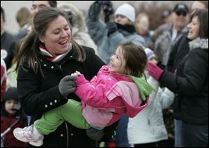 Kristy Weaver of Sylvania dances with her daughter, Ava, 3, as the ball ends its descent. Those attending the zoo's celebration could make a few ReZOOlutions to be a little greener in 2010, watch an ice carving demonstration, or make crafts.
