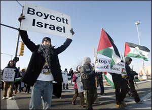 Slug: CTY peace03p A  The Blade/Jeremy Wadsworth  Date: 01/03/2010   Caption: Mohammud Adya, 14, of The Northwest Ohio Peace Coalition marches against Israel's attack on Gaza a year ago Sunday, 01/03/10, on the sidewalk of the boundaries of the Westfield Shopping  Mall in Toledo, Ohio.