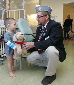 Cecil Harris, 2, gets a Josh Dog at Toledo Children's Hospital from Evan Mahlman, a member of the delegation from Maumee Post 320 Sons of the American Legion. 
<br>
<img src=http://www.toledoblade.com/graphics/icons/photo.gif> <font color=red><b>VIEW</font color=red></b>: <a href=