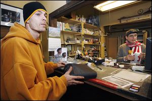 Allen Schiffler, left, brings his computer in for a loan from Nick Koka of Standard Loan.