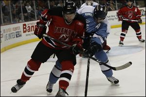 Trenton's Jack Combs, left, battles Toledo's Malcolm MacMillan near the Devils' goal in the second period.
