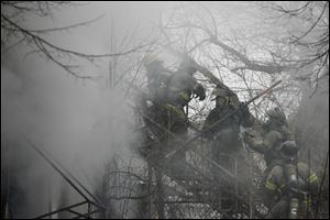 Toledo firefighters battle a blaze at 573 Segur Ave. in South Toledo. It took crews two hours yesterday to extinguish the fire, which is suspected to be arson. Toledo fire Battalion Chief Jerry Abair said the rear door of the vacant two-story building was open and someone had ignited a pile of trash inside.