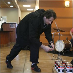 Tavis Glassman adds money to the Red Cross containers during the fund-raiser at Caffeini's Coffee. At Owens Community College this week, students are organizing a disaster-relief supply drive to benefit the Haitian survivors.
