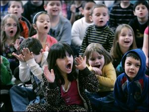 Students at Wayne Trail Elementary in Maumee, including Kristian Birr, 5, Monica DeGasto, 5, Sydney Ervin, 5, and Nicholas Johnstone, 6, from left in front, react in shock and wonderment as they watch a science demonstration at their school Thursday.