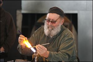 Italian artist Gianni Toso crafts a miniature mask at the Glass Pavilion. Mr. Toso was part of the draw, it seemed, for people to stop sledding and admire his whimsical figurines.