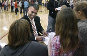 Mohammed Darabie of BGSU's Center for International Comparative Education jokes with Perrysburg students as he writes their names in Arabic.