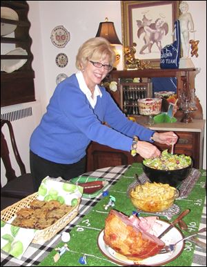 Marlene Uhler tosses a salad for guests at her Super Bowl party.