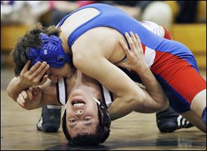 Alex Gearig of Springfield prepares to pin Daniel Jewell of Rossford in Saturday's 119-pound championship match at Perrysburg High School. The Blue Devils won three individual titles. 