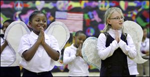 Slug: CTY program20p Date:  02192010     Andy Morrison       Location: Toledo Caption: Marvin Burwell, left, and Taylor Tennant, right, sing a song about angels with fellow second graders during a Black History Month program at Old West End Academy, Friday, 02192010. Summary.