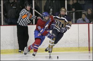 Ben Torchia of St. Francis, left, controls the puck in a Jan. 29 game against rival St. John's. Tickets for the game were sold out two days before the game.