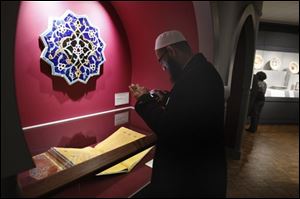 Imam Sohel Mangera photographs a Qur'an from about 1450-60 displayed at the Detroit Institute of Art in Detroit, Wednesday, Feb. 23, 2010. In the heart of the largest concentration of Muslims in the U.S., the Detroit Institute of Arts opens its new permanent gallery of Islamic art. The gallery of about 170 works of art from the Mediterranean region, the Middle East, Central Asia and India opens Sunday.