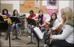 Toledo School for the Arts students, from left, Melia Norden, Kyrha Benson, Raelyn Santoro, and Brianna Ruiz listen to presenter Jilly Mae play.