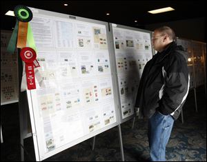 Slug: CTY stamp01p Date:  02282010     Andy Morrison       Location: Toledo  Caption: Dave Weber, Toledo, looks at a display of stamps featuring Japanese National Parks at the 86th Annual Toledo Stamp Expo '10, at Holland Gardens, Sunday, 02282010. Summary.