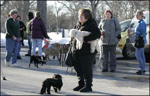 Supporters of a proposed dog park - including Tina Yoppolo, center, with Bella, on the ground, and Max, in her arms - watch as the Ottawa-Jermain advisory board holds a news conference. 
