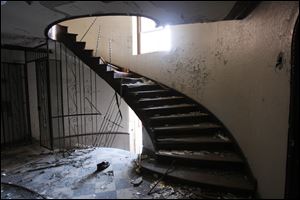 Peeling walls and ceilings and twisted ironwork are features of a stairwell in one of the buildings.
The structures are exposed to the elements, and their rooms are filthy and strewn with trash.