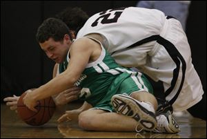 Ottawa Hills J.J. Buckey, left, battles Norwalk St. Paul's Brian Griffin for a loose ball. Buckey led the Green Bears with 17 points.
<br>
<img src=http://www.toledoblade.com/graphics/icons/photo.gif> <font color=red><b>PHOTO GALLERY</b></font>: <a href=