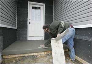 BIZ build14p  3/11/2010  The Blade/Dave Zapotosky Caption: Duane Scott of Scott's Quality Concrete, Inc., Sylvania, finishes the porch on a home under construction in the new Lakeside  subdivision off of Monclova Road near Strayer Road in Monclova Township, Thursday, March 11, 2010.  It is the only home currently under construction there.