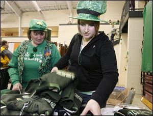 Donna Strong, left, and her daughter Nicole Strong, sport Irish-themed clothing as they examine a vendor's wares at the annual celebration of St. Patrick and the Irish heritage.