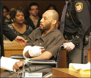 Steve A. James, shot in an alleged robbery attempt, is taken from Toledo Municipal Court after his arraignment yesterday.