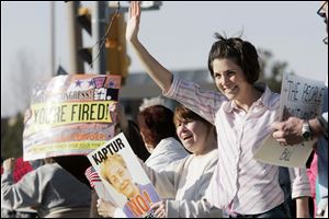 the blade/amy e. voigt Amanda Metcalf, right, and Mary Mangold of Toledo protest at the corner of Cherry and Summit streets. The Children of Liberty, a conservative-libertarian group, organized the demonstration.