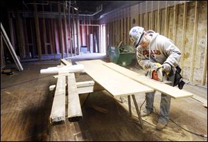 Slug: BIZ BUILD21p  Date:  03162010     Andy Morrison       Location: Toledo Caption: Matt Reynolds, a carpenter with The Spieker Company, Perrysburg, cuts wood to repair damaged floor of the new home of Thomas Porter Architect at 8 North St. Clair Street, Tuesday, 03162010. This actual part of the building is being renovated to be leased out. Summary.