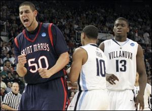 Saint Mary's Omar Samhan (50) celebrates in front of Villanova's Corey Fisher (10) and Mouphtaou Yarou in the second half.