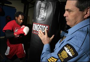 Sergeant Youngs assists Mr. Alexander with his workout, right.