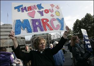 Outside Rep. Marcy Kaptur's Toledo office, the Rev. Angela Zimmann, president of the Lucas County Educational Services Center, joins a rally thanking Miss Kaptur for backing health reforms.
