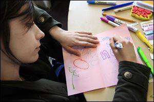 Owens student Lydia Kwapich of Waterville colors a card designed to uplift a cancer patient.