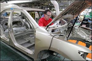 A component goes into a Camry at Toyota's factory in Georgetown, Ky. Camry models are included in the incentive programs.