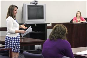 Jessica Walls, left, of Otsego High School acts as defense attorney
while Heather Booth of Eastwood High School, foreground, serves as prosecutor during a session of the Teen Court program. Looking on is Christy Snyder, director of youth services.