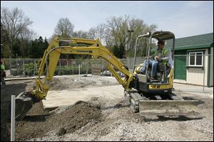BIZ build18p  Bill Dittman, of Toledo, smoothes the ground adjacent to the new building. This area will be the new gardening area. Rudloph/Libbe workers are building an addition to The Anderson's store at Talmadge and Monroe in Toledo, Ohio on April 14, 2010. Jetta Fraser/Toledo Blade