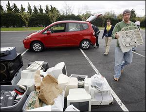 Slug: CTY earthday17p B The Blade/Jeremy Wadsworth    Date: 04/17/10  Caption: Joe Neeb of Toledo, Ohio, drops of an old computer to be recycled Saturday, 04/17/10, at the Toledo Zoo during Earth Day festivities.