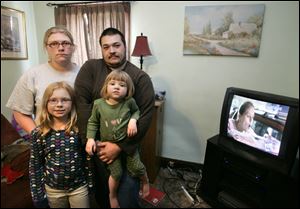 'We are to the point where we do not feel safe in our home,' says Rachel Parrish, with Jeffrey Brown and her children, Macenzy Haley, 7, left, and Jadyn Parrish, 2. The East Toledo burglary victim says the family is considering leaving the city.