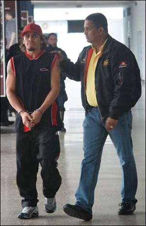 Venezuela's former lightweight boxing champion Edwin Valero, left, is escorted by a police officer to a police station in Valencia, some 150 kms (some 93 miles) west of Caracas, Sunday, April 18, 2010. Venezuelan police said they detained the suspended WBC lightweight champion Valero on suspicion of killing his 20-year-old wife Jennifer Vieira, whose body was found in a hotel in Valencia. 